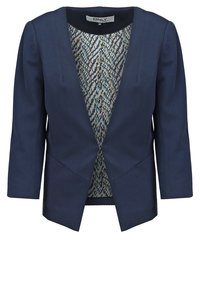 Blazer bleu marine pour femme avec manches trois-quarts, devant ouvert et doublure intérieure à motif dans des tons de bleu, gris et moutarde.