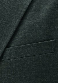 Dark gray textured fabric suit jacket with a slanted chest pocket and visible stitching along the edges.