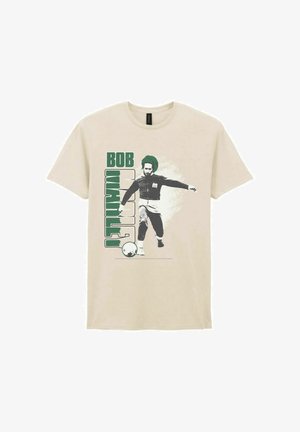 Camiseta beige con texto verde "Bob Marley" y gráfico de un hombre pateando un balón de fútbol, que lleva un sombrero y ropa deportiva.