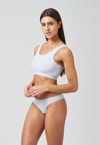Hellgrauer Sport-BH und passender Slip, aus weichem, dehnbarem Material gefertigt. Mit rundem Ausschnitt und breiten Trägern für zusätzlichen Komfort.