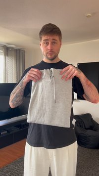 Gray sweatshirt with a drawstring hood, held upright. Material appears soft, with a clean design and no visible patterns or accents.