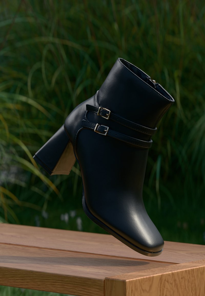 Musta pahklu suss, mis on valmistatud siledast nahast, kahe pandla ja ruudukujulise kannaga, millel on veidi läbipaistev detail.