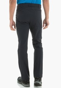 Men's navy outdoor pants with a fitted design, durable fabric, zippered back pocket, and contrasting stitching detail.