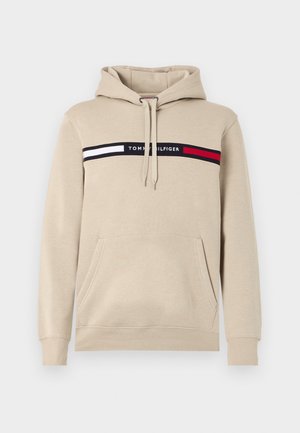 Beżowy sweatshirt z kapturem, z przednią kieszenią, z czarno-biało-czerwonym wzorem w paski oraz z logo "TOMMY HILFIGER" na piersi.