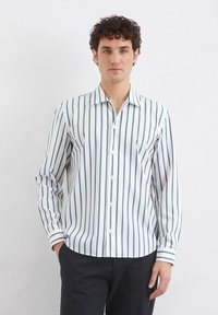 Gestreiftes Button-Down-Shirt in Weiß und Marineblau, mit langen Ärmeln, einem klassischen Kragen und einem abgerundeten Saum. Glattes, leichtes Material.