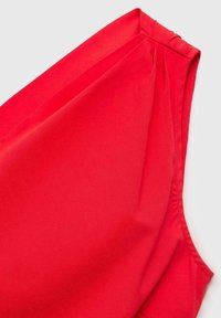 Haut sans manches rouge avec une texture lisse, un design légèrement drapé et des détails froncés aux épaules.