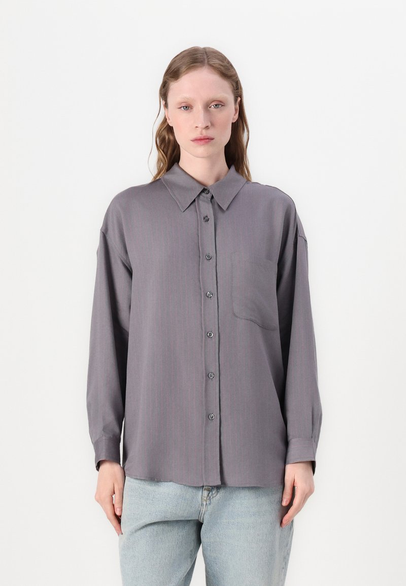 Camisa cinza de botão com riscas verticais cor-de-rosa, colarinho espalhado, bolso frontal e mangas longas. Textura suave, ajuste descontraído.