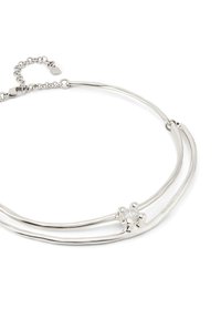 Collar de tono plateado que presenta dos hebras curvas entrelazadas con un acento central de cristal transparente y cierre de langosta.