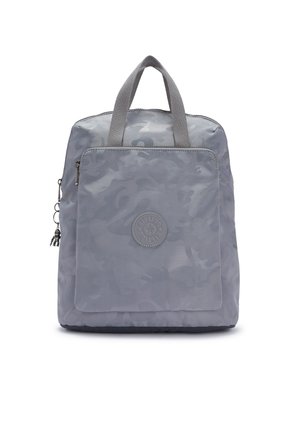 Sac à dos carré gris avec motif camouflage, poche avant zippée, deux poignées courtes et un petit porte-clés singe sur la languette de la fermeture éclair latérale.