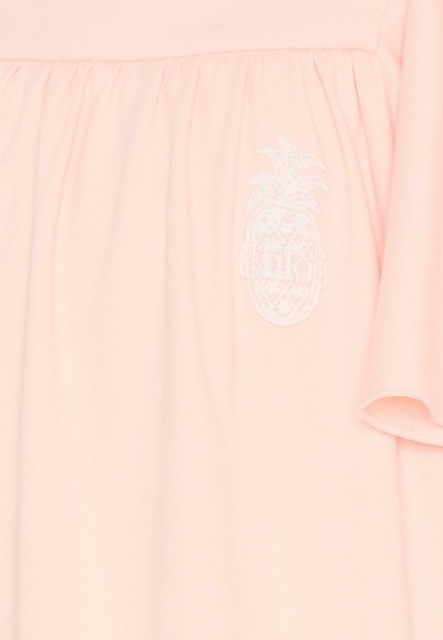 Jasnoróżowa sukienka z krótkim rękawem, z marszczonym materiałem w talii i białym haftowanym logo ananasa na przodzie.