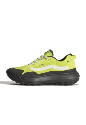 Zapatilla Vans baja en amarillo y negro con franja lateral blanca, suela negra, cordones blancos y tira para tirar en el talón, mostrada desde el lado exterior.