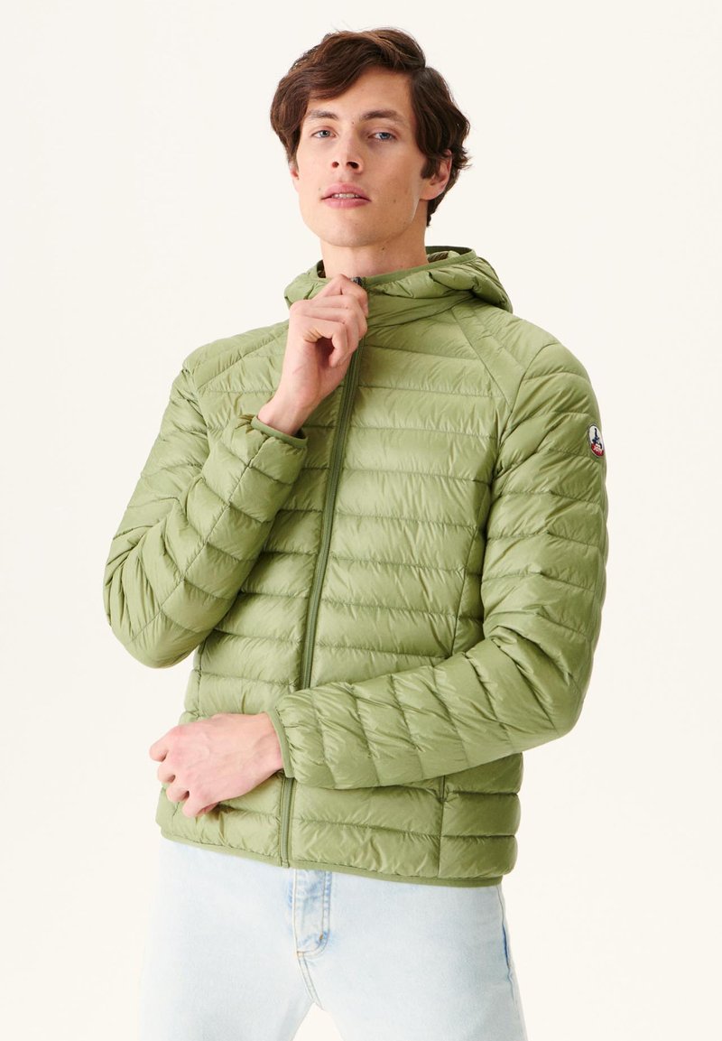 Chaqueta ligera y acolchada en verde oliva. Con cremallera completa, capucha y textura acolchada con un pequeño logo en la manga.