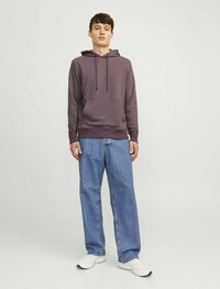 Purple hoodie with a kangaroo pocket, adjustable drawstrings, and logo. Paired with light blue straight-leg jeans and white athletic shoes.