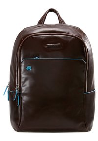 Mochila de cuero marrón con una textura suave, presenta un bolsillo frontal con cremallera, acentos azules y un asa superior para un transporte fácil.