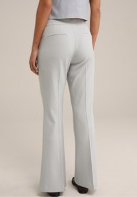 Light gray, flared trousers with a smooth texture, featuring two back pockets and a mid-rise waist. Pairing with a cropped top.