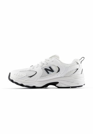 Scarpa da ginnastica bianca con tomaia in rete e materiale sintetico. Presenta un accento nero e una suola in gomma texturizzata per una migliore aderenza. Design con lacci.