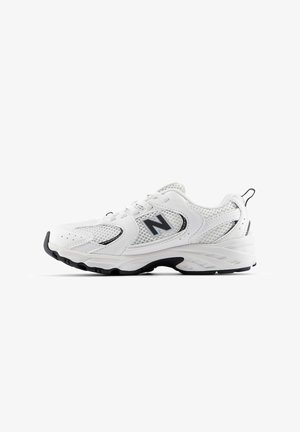 Baskets de sport blanches avec une tige en maille et synthétique. Présente un accent noir et une semelle en caoutchouc texturé pour l'adhérence. Système de laçage.