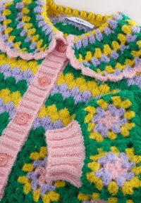 Cardigan lavorato a maglia con motivi floreali e geometrici multicolori in verde, giallo, viola e rosa, caratterizzato da una patta con bottoni e colletto a coste rosa.