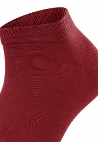 Czerwona skarpetka za kostkę wykonana z gładkiego, elastycznego materiału z prążkowanym mankietem. Posiada bezszwowy design i ściśle przylega do stopy.