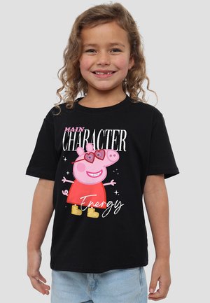 Black t-shirt featuring a cartoon pig character in red dress and heart-shaped sunglasses, with white and pink text reading "MAIN CHARACTER Energy."