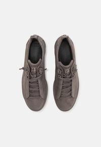 Šedé semišové tenisky s kulatým tvarem, vybavené elastickými tkaničkami, hladkou texturou a nenápadným logem na jazyku.