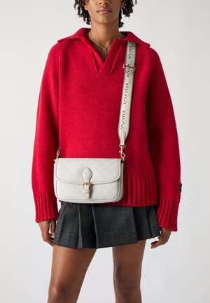 Červený pletený sveter s výstrihom do V a rebrovanými manžetami, skombinovaný s kockovanou plisovanou sukňou a krémovou crossbody taškou so zdobeným uzáverom.