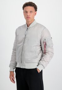 Svetlo šedá bomber bunda s rebrovými manžetami a lemom. Obsahuje zips, bočné vrecká a úžitkové vrecko na ľavom rukáve.