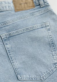 Light blue denim jeans featuring a back pocket with subtle stitching and a brown leather patch labeled "DENIM SUPPLY." Soft texture.