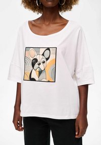 Biała bawełniana koszulka o prostym kroju i szerokim dekolcie, z kolorowym haftem przedstawiającym francuskiego buldoga w geometrycznym stylu.