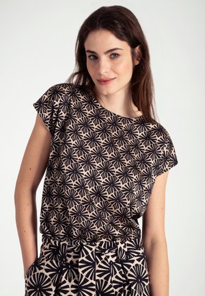 Zwart en beige t-shirt met korte mouwen met een bloemenpatroon, gemaakt van zachte stof met een relaxte pasvorm, gecombineerd met een broek met patroon.