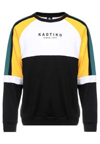 Svart sweatshirt med färgblockeringsdesign i gult, vitt och teal. Har logotypen "KAOTIKO SINCE 1999" på framsidan. Ribbad ärm- och halsringning.