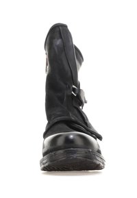 Botín negro de cuero con una puntera brillante, caña de ante suave y cremallera lateral. Presenta una correa decorativa en la parte superior.