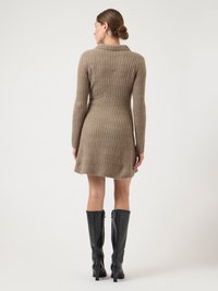 Rochie din tricot striat, până la genunchi, de culoare maro deschis, cu guler larg și mâneci lungi, asortată cu cizme negre până la genunchi.