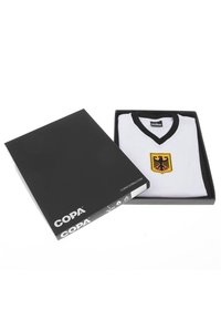 White soccer jersey with black V-neck and German eagle crest, neatly folded in an open black COPA-branded box.