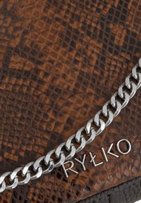 Borsa con motivo di pelle di serpente marrone, dotata di una tracolla in catena argentata e del logo "RYŁKO" impresso nella parte inferiore. Finitura in pelle testurizzata.