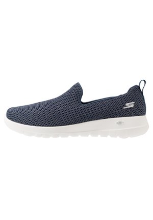 Granatowy sneaker typu slip-on z oddychającą siateczkową cholewką, białą podeszwą oraz logo Skechers po boku i na pasku na pięcie.