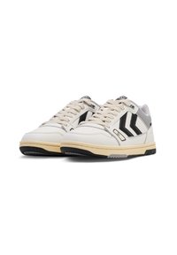 Hvit lær sneakers med svarte og grå detaljer. Har en avrundet tå, teksturert såle og klassisk snøring. Viser merkbar sidelogo.