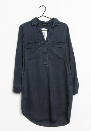 Mörkblå långärmad skjorta med krage, två framfickor, knäppning fram och rundad nederkant. Tillverkad av lätt tyg med en mjuk textur.