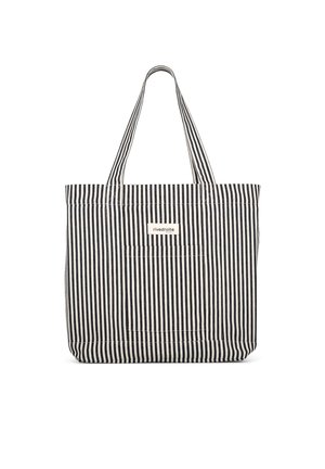 Sac cabas en tissu à rayures verticales noires et blanches avec deux poignées et une petite étiquette rectangulaire à l'avant.