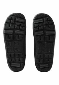 Czarne gumowe podeszwy butów z teksturowanymi powierzchniami, z różnorodnymi wzorami bieżnika i wbudowanym logo, zaprojektowane z myślą o trwałości i przyczepności.