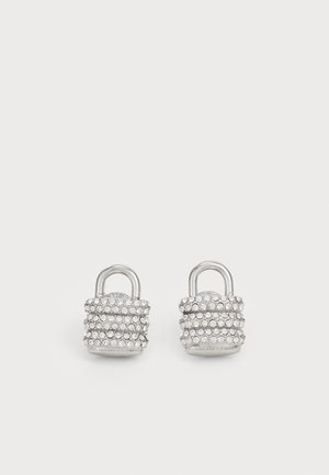 Sudraba auskari, kas izskatās pēc slēdzēm, rotāti ar vairākiem caurspīdīgiem rhinestones, ar gludu, spīdīgu tekstūru un vienkāršu cilpu stiprināšanai.