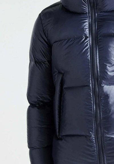 Giacca imbottita blu navy con finitura lucida, dotata di una cerniera frontale e una tasca laterale. Il design presenta sezioni trapuntate per l'isolamento termico.