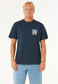 Navy blue cotton T-shirt featuring a small graphic logo on the left chest, paired with light blue denim shorts. Standard fit and crew neckline.