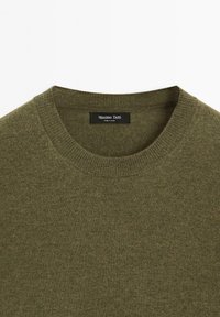 Maglione verde oliva con collo a girocotola a coste, morbido al tatto, composto da un fine filato, e un'etichetta nera che riporta "Massimo Dutti."