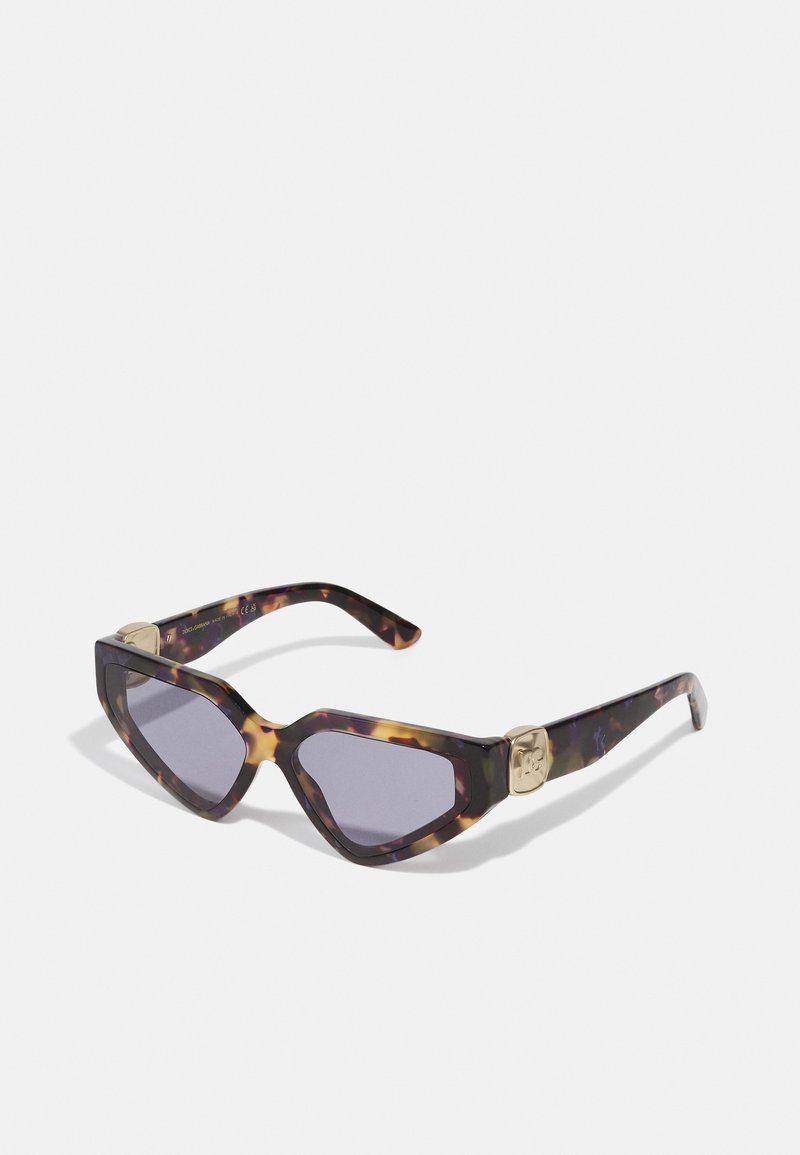 Sunglasses with a tortoiseshell frame, angular design, dark lenses, and gold hardware accents on the temples.