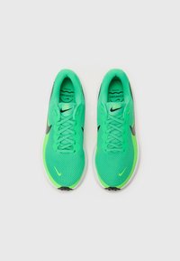 Zapatillas de correr de malla verde con acentos negros, que cuentan con un upper texturizado, puntera redonda, cierre de cordones y una suela blanca acolchada.
