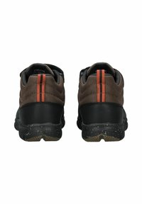 Scarpe da ginnastica marroni e nere con un design trapuntato, dotate di due strisce arancioni sul tallone e una suola testurizzata con dettagli maculati.