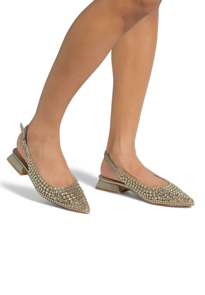 Chaussures slingback à bout pointu en beige, ornées de clous en argent. Dotées d'un petit talon carré et d'une tige en tissu texturé pour plus de détails.