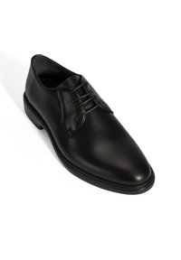 Schwarze Leder-Schuh mit glatter Oberfläche, runder Zehenform, Schnürung vorne und einer niedrigen Gummisohle. Einfaches Design mit minimalen Details.