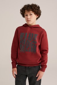 Boravoratė džemperis su pilku užrašu "BLUE RIDGE DENIM". Yra kengūros kišenė ir raukšlėti rankogaliai. Sukombinuota su tamsiais džinsais.